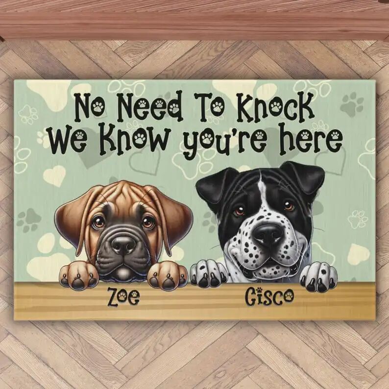 May include: A welcome mat with a green background and paw prints. The text reads 'No Need To Knock We Know You're Here'. Two dogs are shown at the bottom of the mat, one is a brown and tan boxer named 'Zoe' and the other is a black and white dog named 'Gisco'.